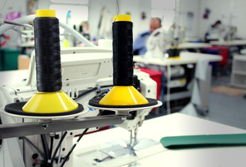 Support British Manufacturing With Openhouse 6 Spools with black thread on top of a sewing machine